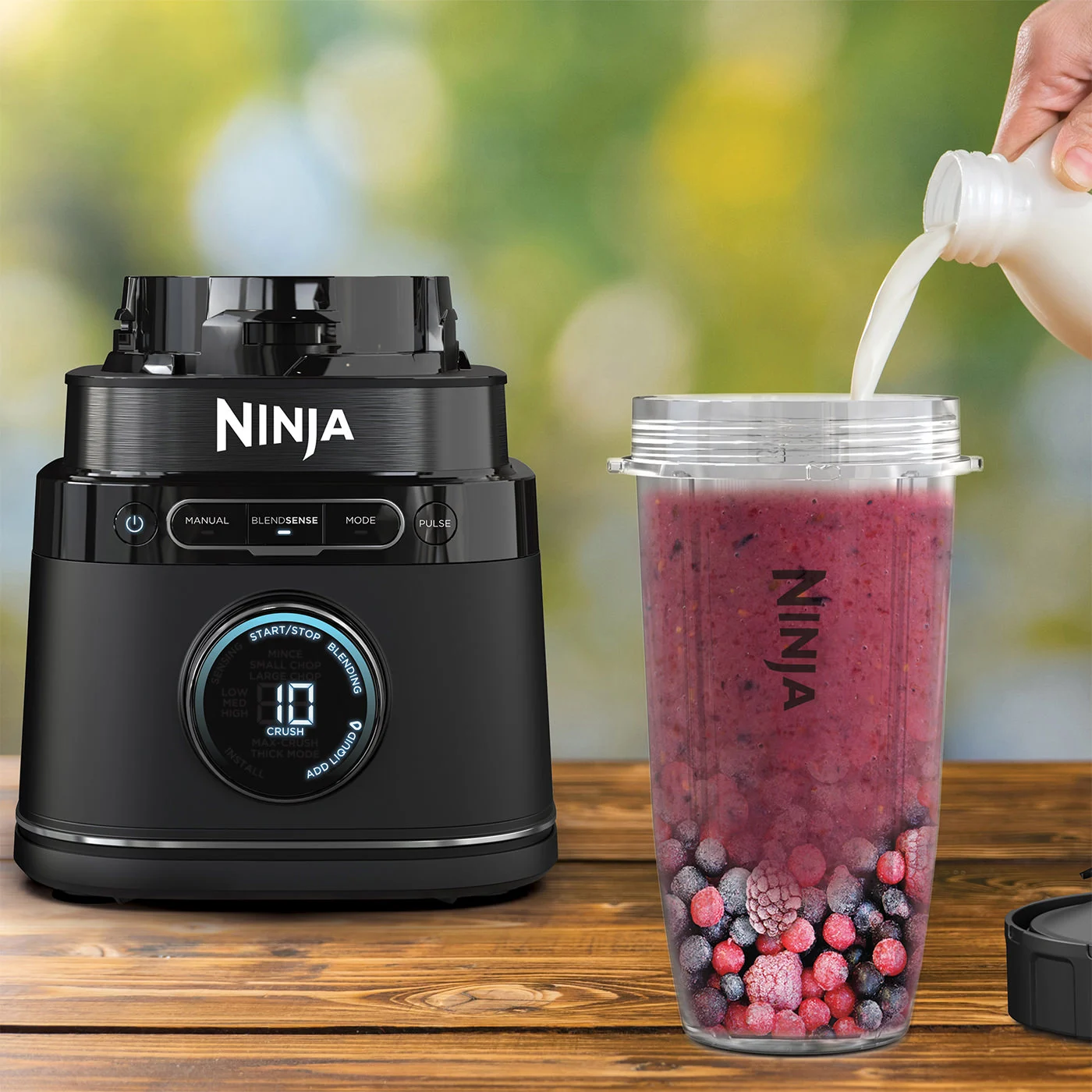 Ninja-R-TB301UK-InUse-OutsideTable-PourMilk-PreMix-Cup