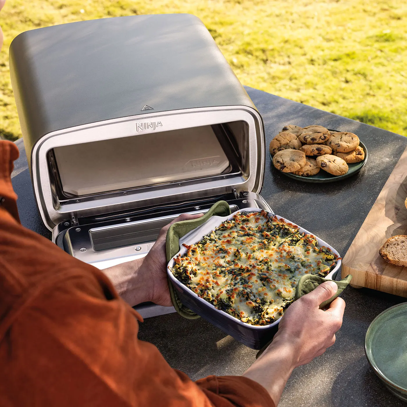 Ninja-MO201UK-InUse-BackYard-OnCounter-RemovingFood-Man